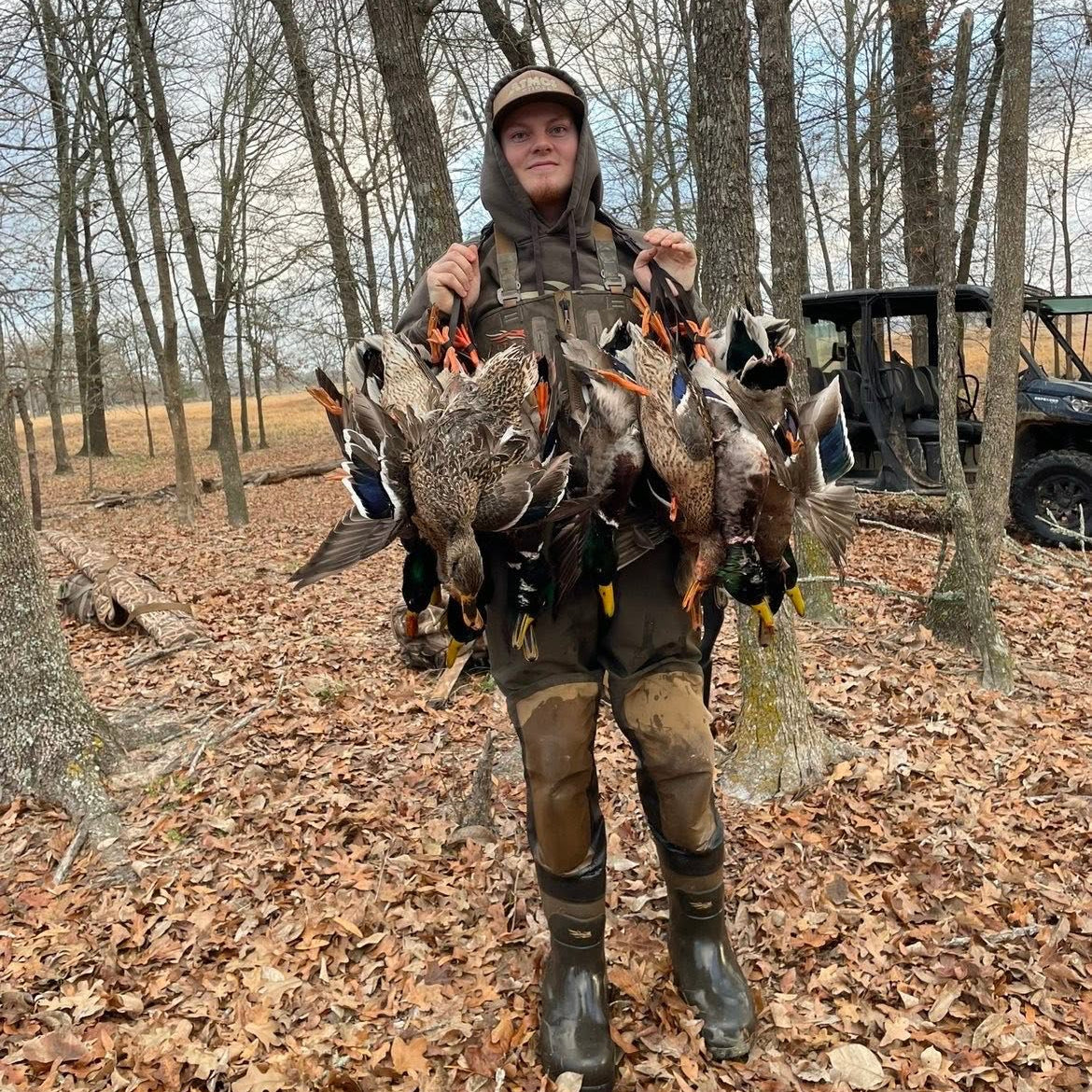 Person holding hunted birds in a wooded area with a truck in the background, waterfowl guide service, Texas duck hunting guide, Oklahoma guide service, duck hunting guide service