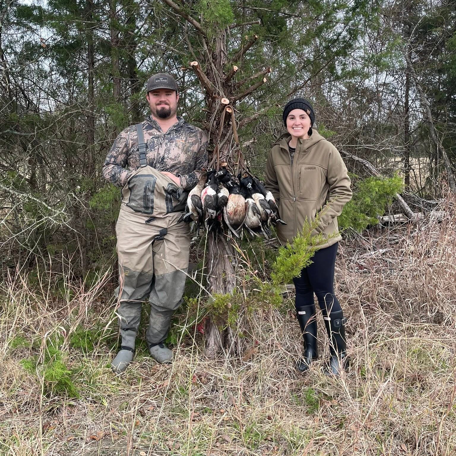 Two people standing in a wooded area with game birds. Waterfowl guide service. Texas hunting guide. Oklahoma hunting guide. Duck hunting guide Texas and Oklahoma.